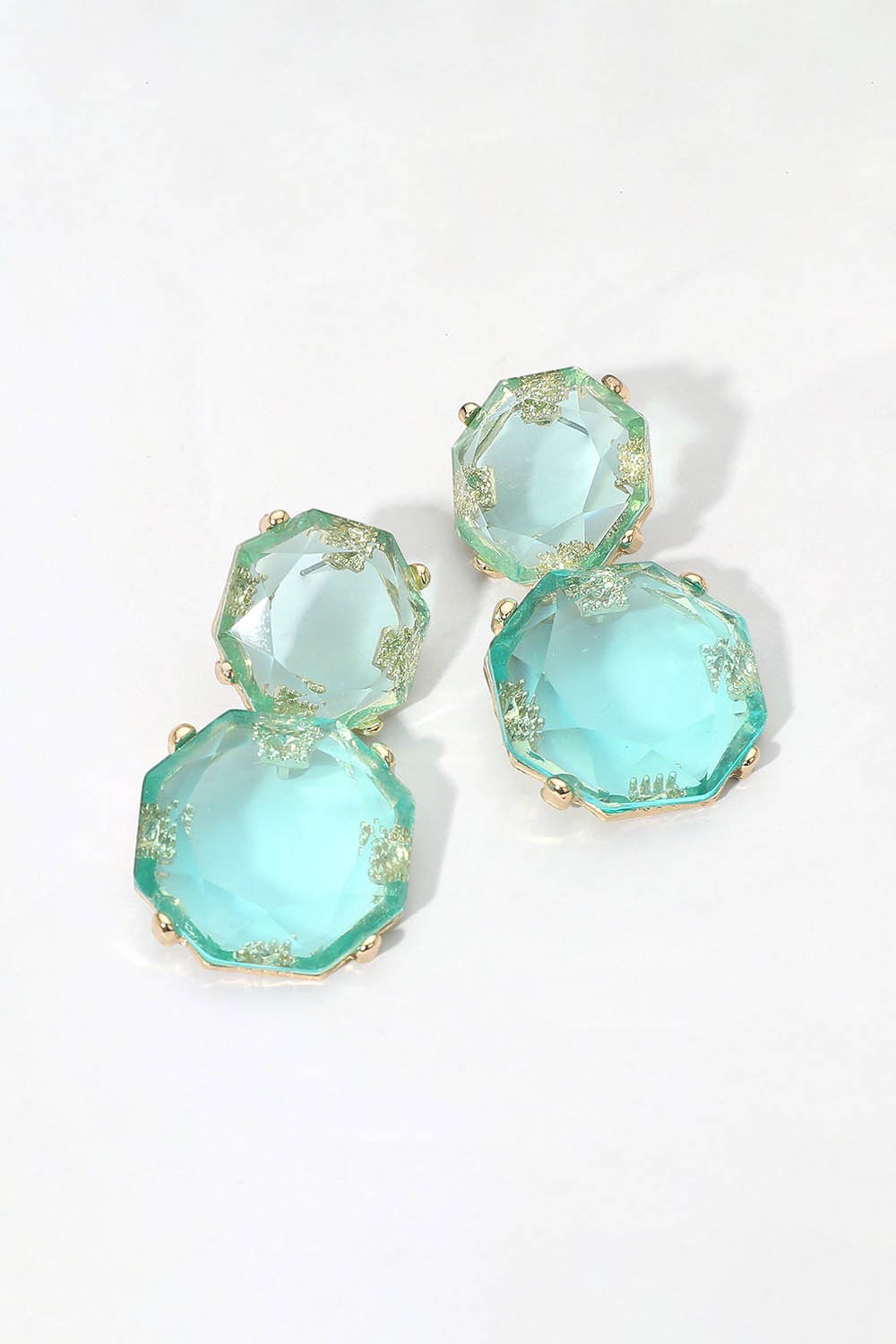 Blue double stone drop earrings with gold settings on white