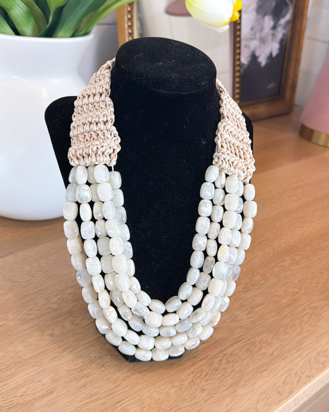 Ivory beaded raffia layered necklace displayed on a black bust