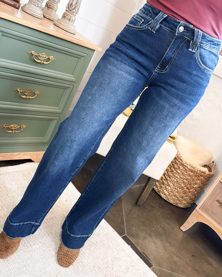 Front view of dark wash high rise wide leg jeans worn with brown ankle boots