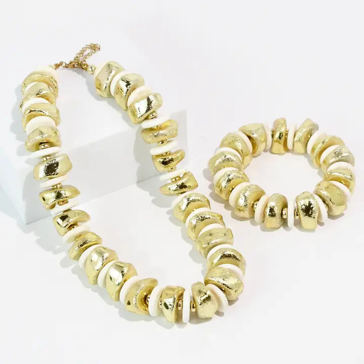 Gold chunky nugget necklace and matching stretch bracelet displayed on a white background