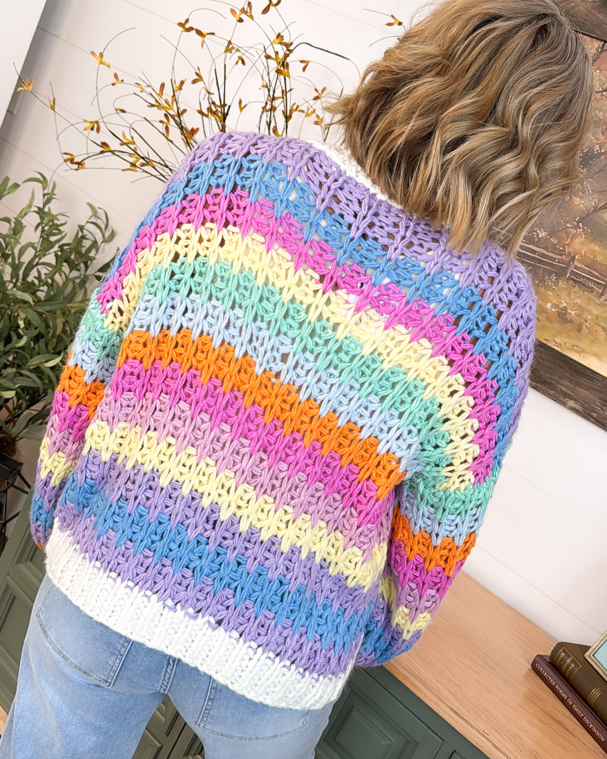 Back view of the pastel rainbow striped crochet cardigan with an ivory ribbed hem