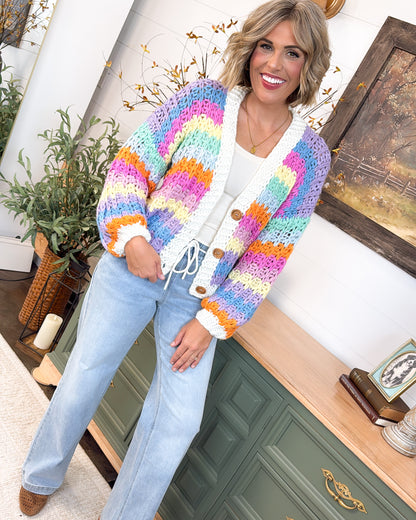 Full-length view of the pastel striped crochet cardigan styled with a cream top and light wash wide leg jeans