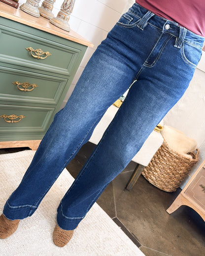 Front view of dark wash high rise wide leg jeans worn with brown ankle boots