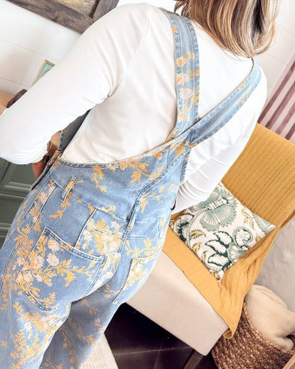 Side view of the mid wash floral denim overall jumpsuit