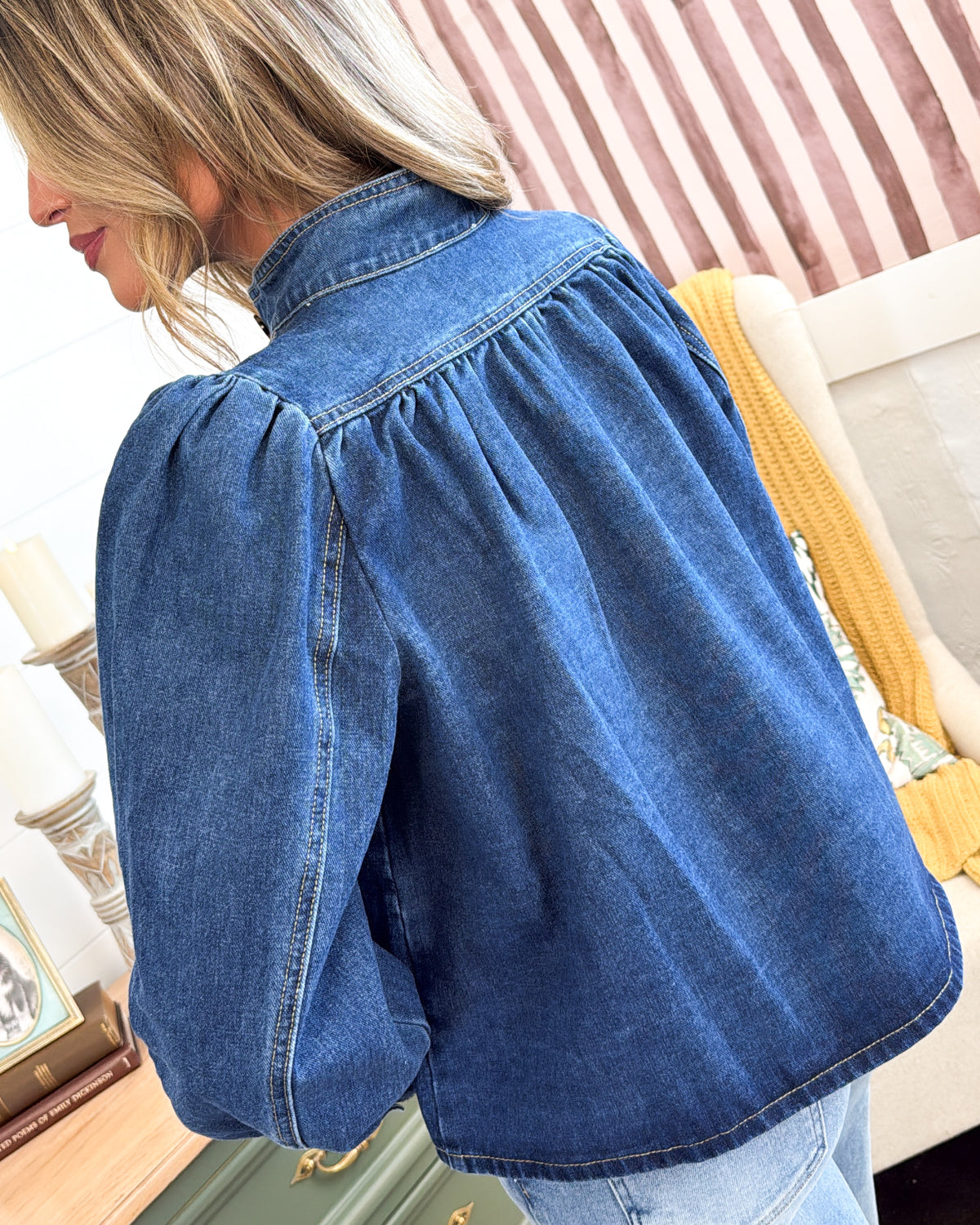 Back view of the medium wash denim jacket showing the pleated yoke and puff sleeves