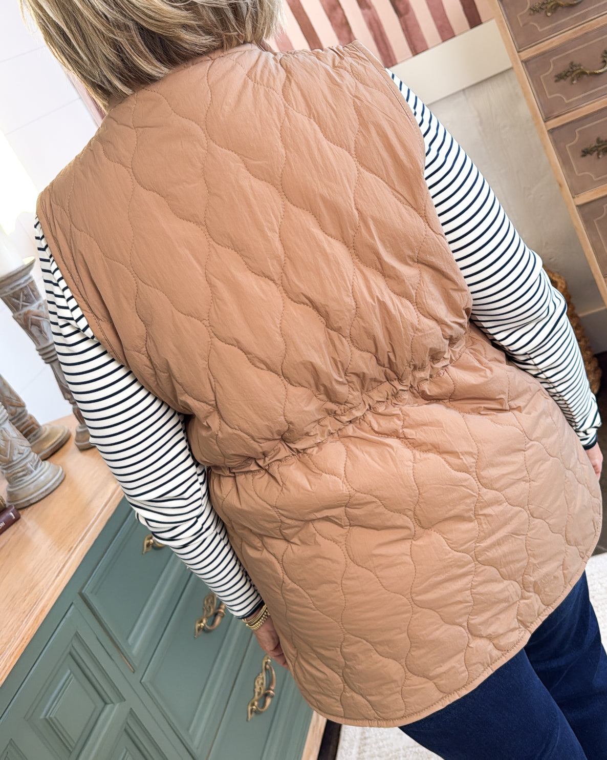 Back view of the tan quilted vest with diamond stitching and cinched drawstring waist