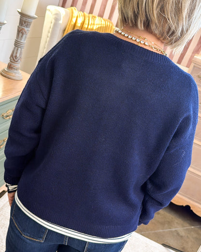 Back view of the navy horse knit cardigan with white striped hem trim