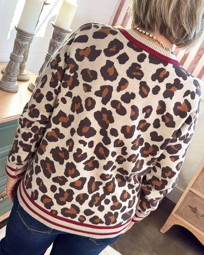 Back view of the taupe leopard print sweater with burgundy and cream striped hem
