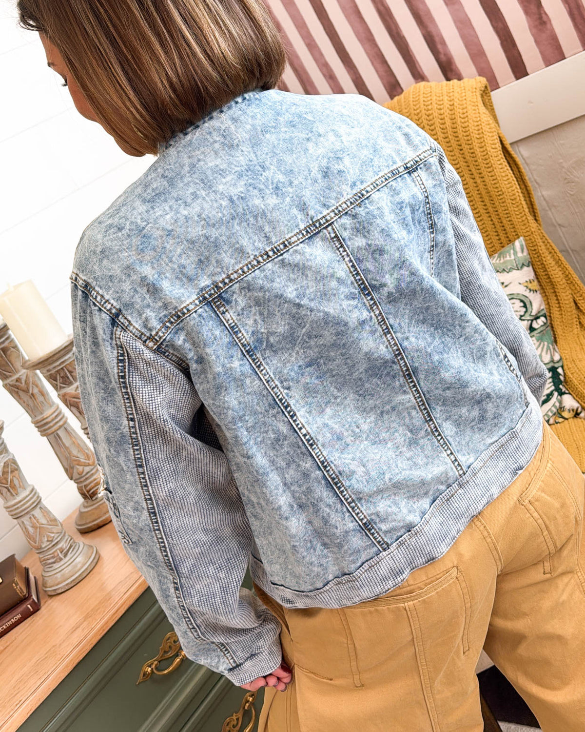 Back view of the light wash denim jacket with knit trim at the cuffs