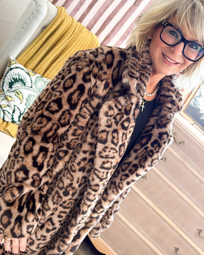 Side view of a camel leopard print faux fur coat with a wide collar